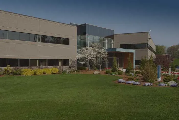 A two-story office building with a landscaped lawn